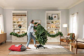 Person adjusting the base of an artificial Christmas tree