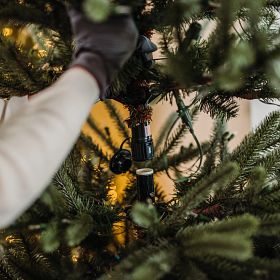 Woman detaching sections of artificial Christmas tree
