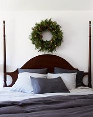 A bed with a wreath hanging above the headboard