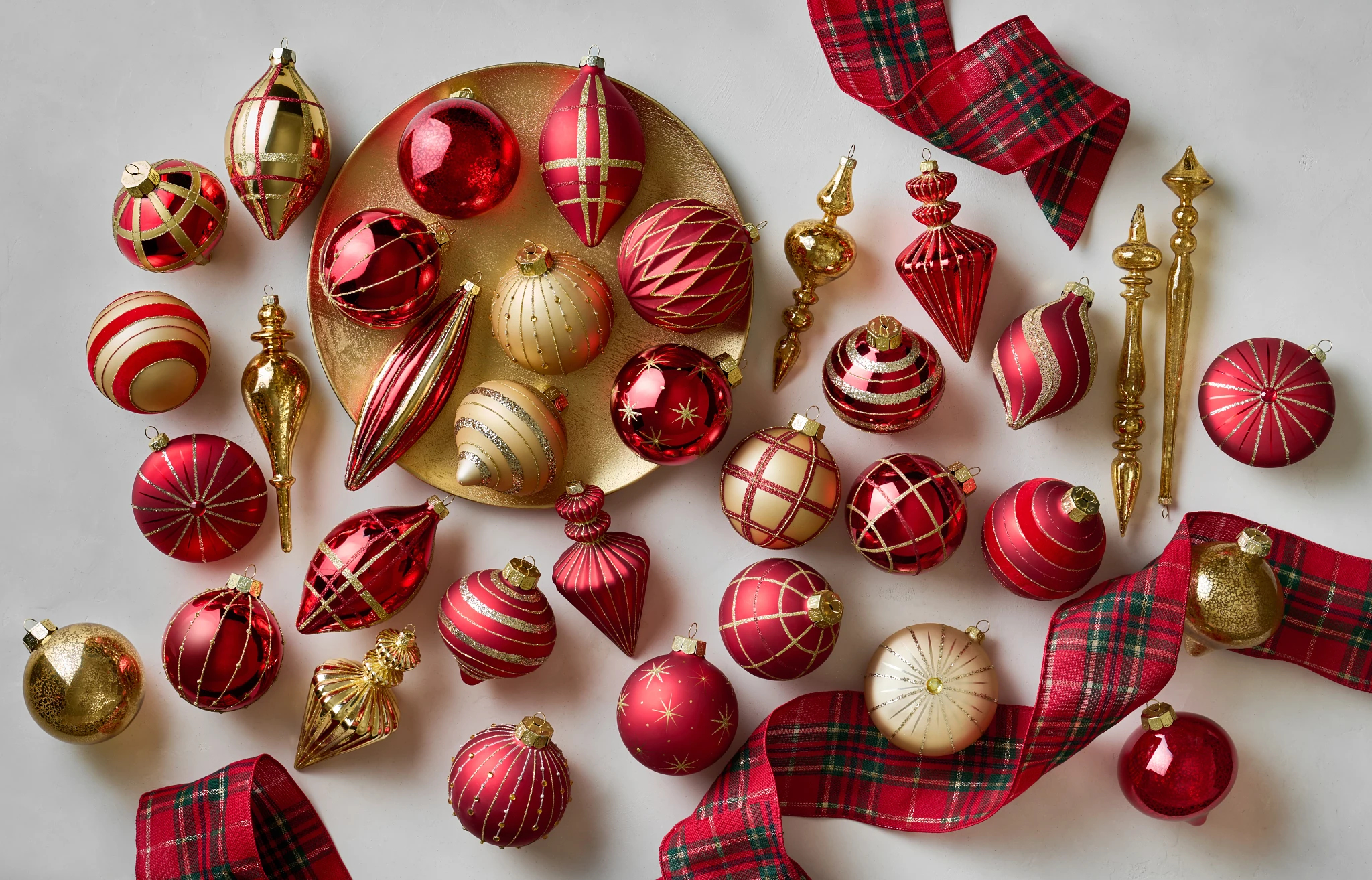 Assorted red and gold Christmas ornaments with red and green plaid ribbon