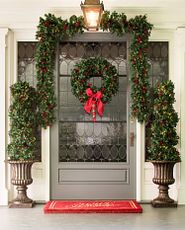 Front door decorated with Christmas greenery