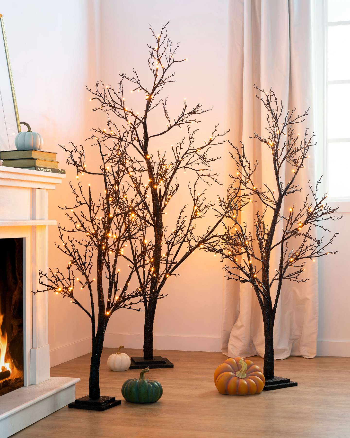 Balsam Hill Halloween Glitter LED Twig Tree Lifestyle Displayed Near a Fireplace