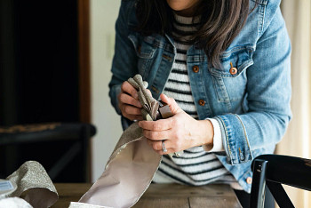 Hands securing a scalloped tree ribbon with a stapler